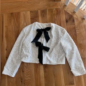 H&M white sequin top with black bow.